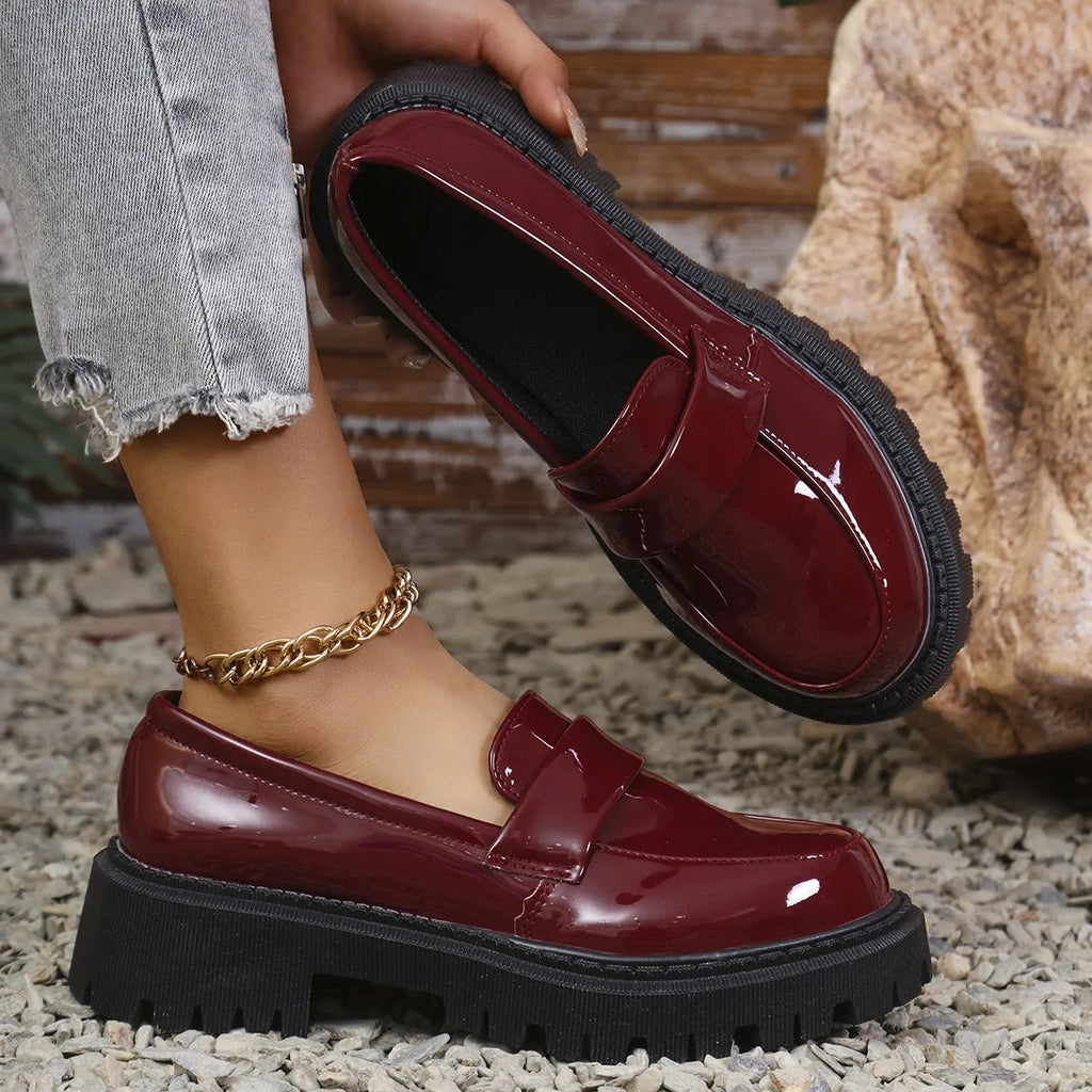 Plus size women's black slip-on loafers with a chunky platform heel and rubber sole.