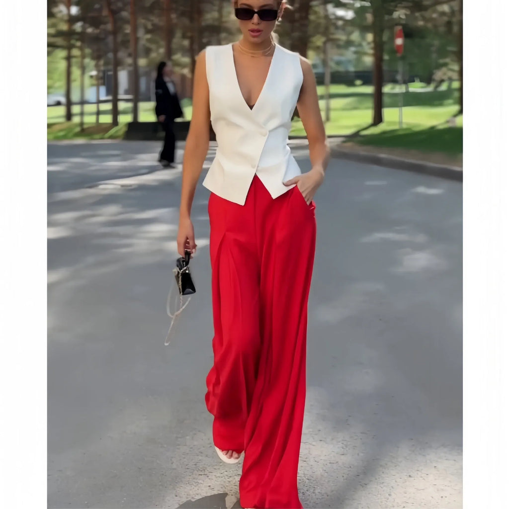 Women's beige two-piece set with deep V-neck sleeveless top and high-waist wide-leg trousers.