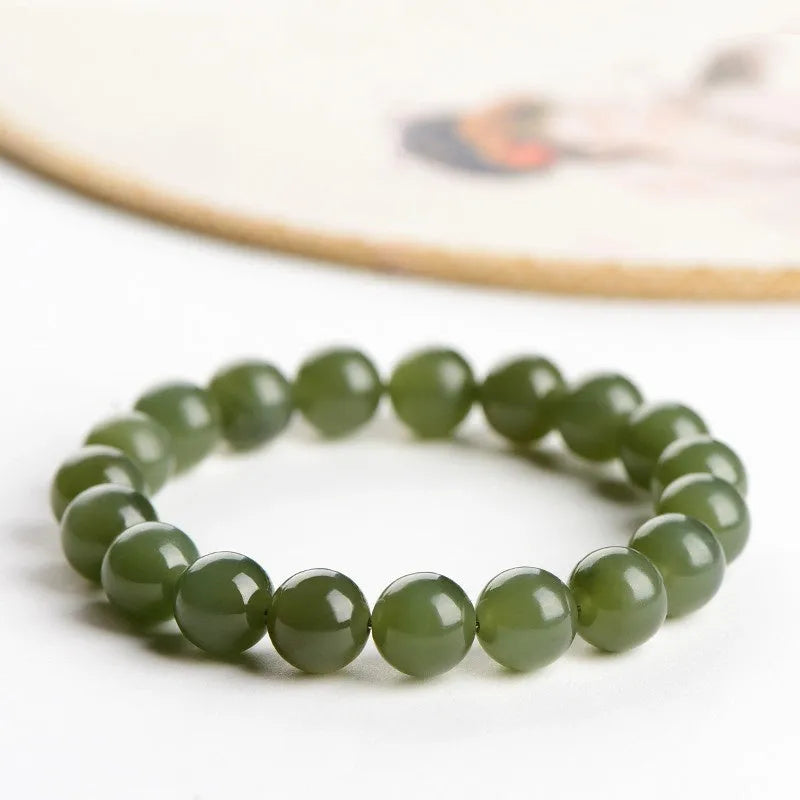 Polished Hetian jade ball bracelet showing spherical beads on a wrist, available in deep or shallow ice-clear colours.