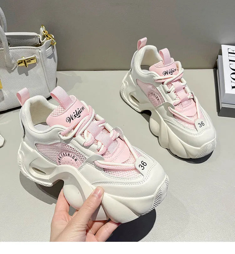 Women's pink casual sneakers with cross shoulder straps and a thick sole.