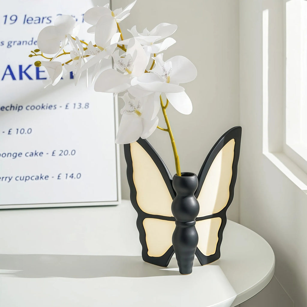 Ceramic butterfly vase and matching tissue box set on a living room table.