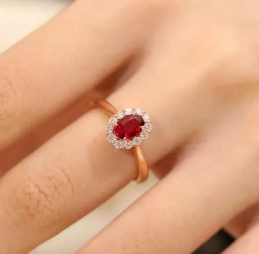 Women's silver ring with gold pigeon design and red artificial gemstone centre.