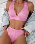 Women's pink halter strap bikini set with matching shorts on mannequin