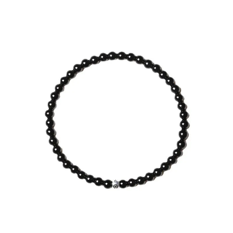 Geometric stone bracelet with obsidian, blue san, and black agate 4mm beads on a wrist.
