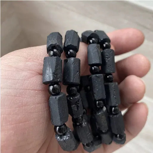 Natural black tourmaline rough stone bracelet showing authentic crystal texture on approximately 9mm beads