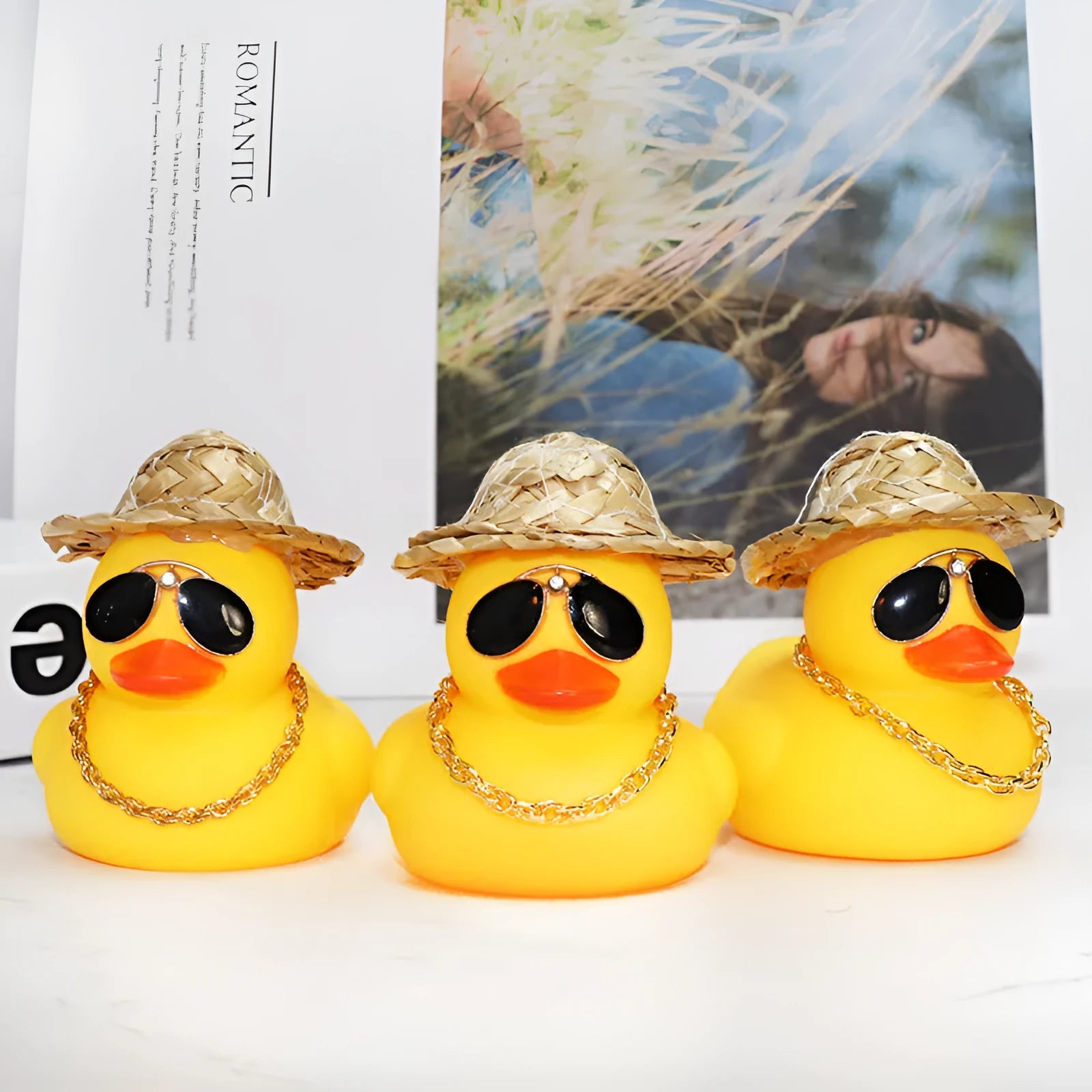 Yellow duck car ornament wearing straw hat with removable sunglasses necklace on dashboard