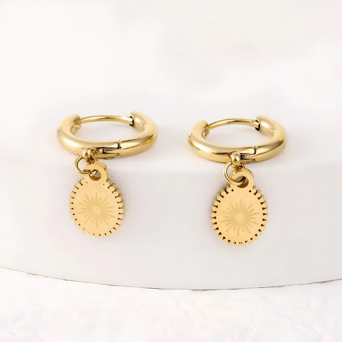 Stainless steel geometric earrings with oval accents on white background