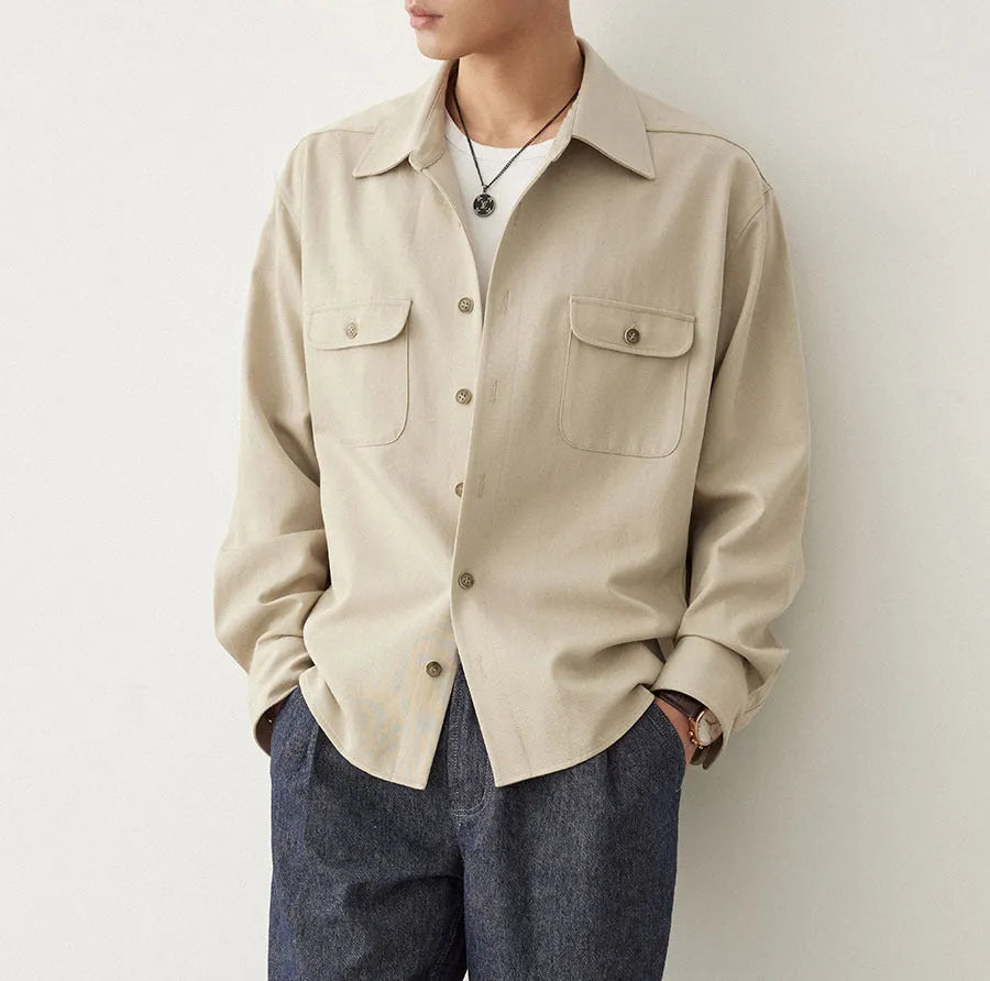 Men's light sand rice long sleeve collared shirt with collage stitch detailing on front.