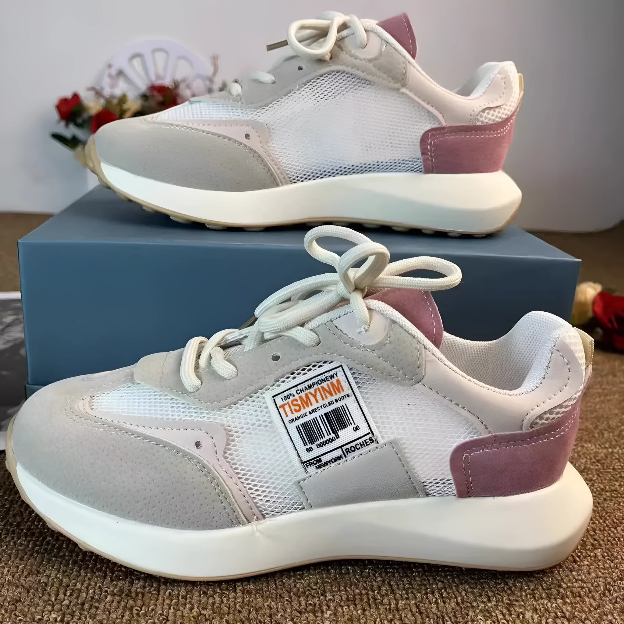 Women's grey and pink retro low-top sneaker with round toe and rubber sole.