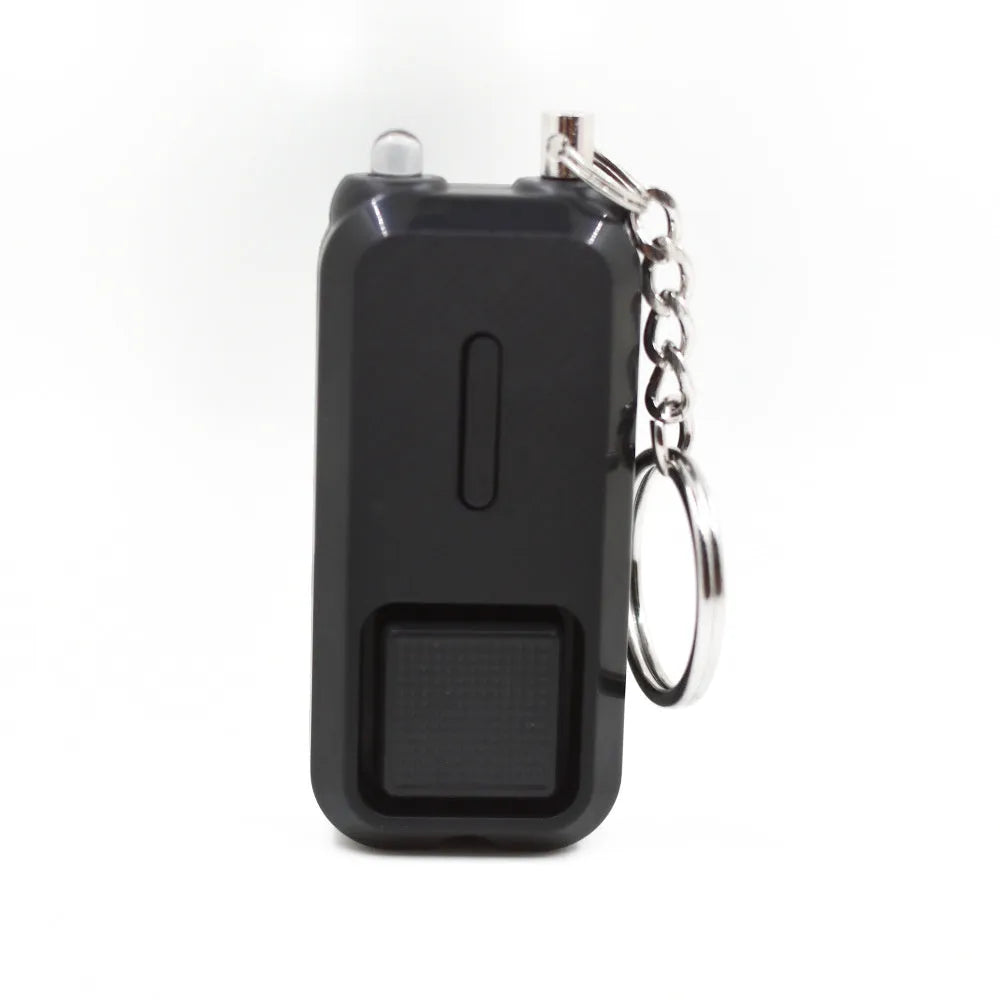 Small pink personal safety alarm on a keyring with a white box.