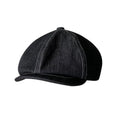 Black cotton retro-style beret for men and women on a plain background.