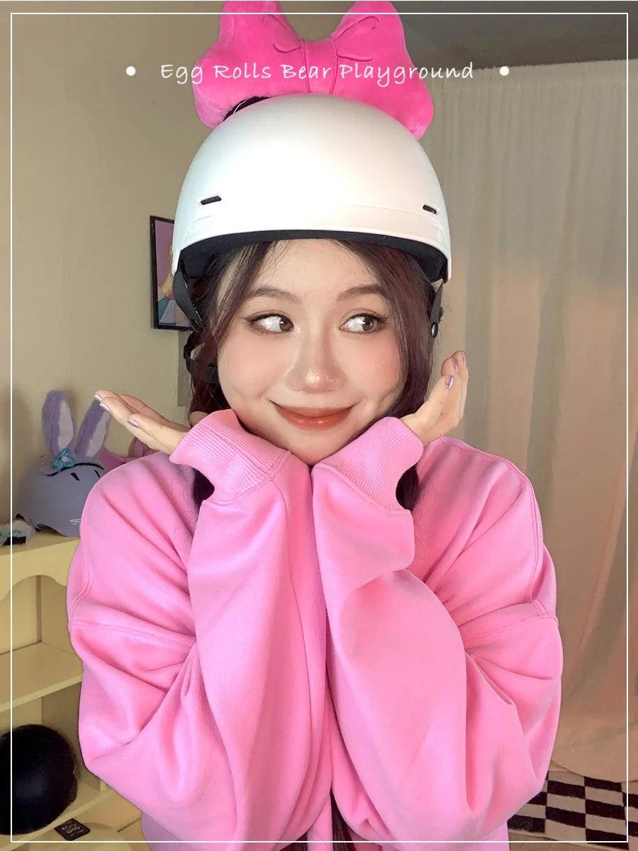 A soft plush bow tie helmet decoration shown in red, peach pink, and rose pink colours.