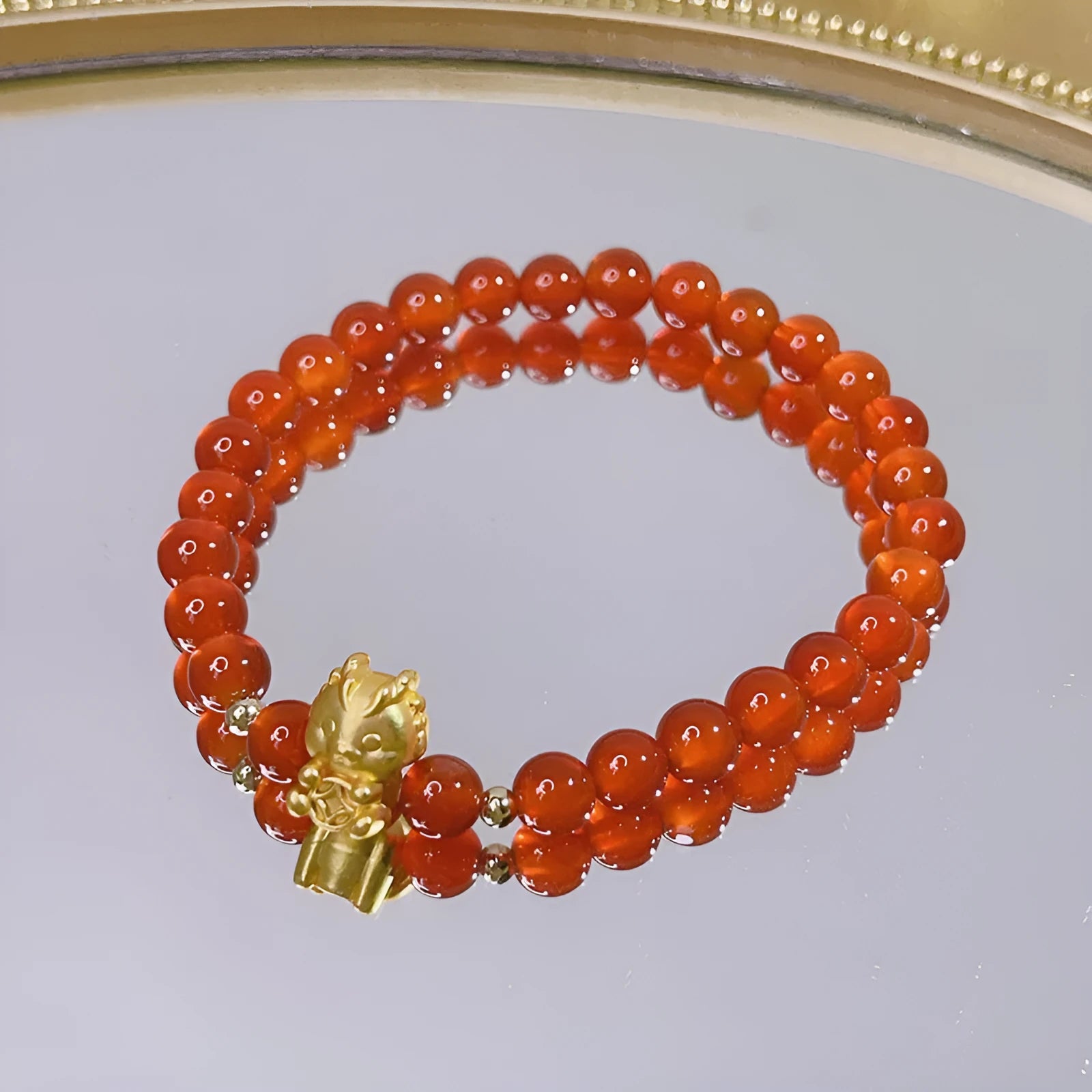 Women's red agate bracelet with manual Chinese dragon and lucky bag designs.