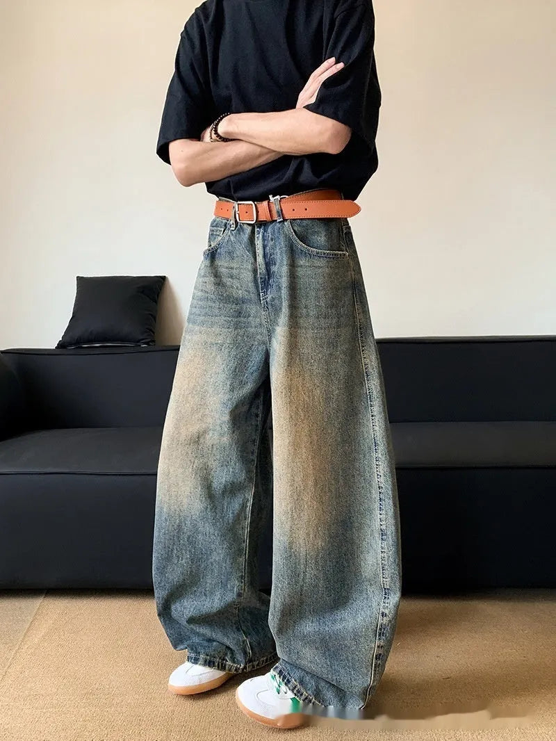 Men modelling retro blue distressed wide-leg jeans with machete detailing and a slimming fit.