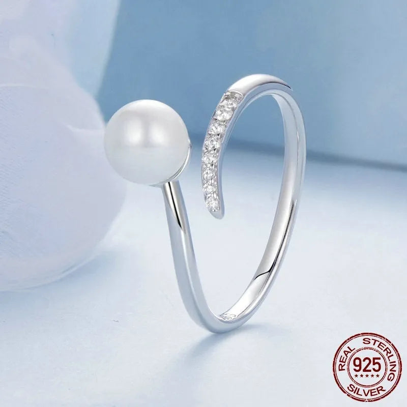 Women's adjustable sterling silver ring with shell pearls and open loop design