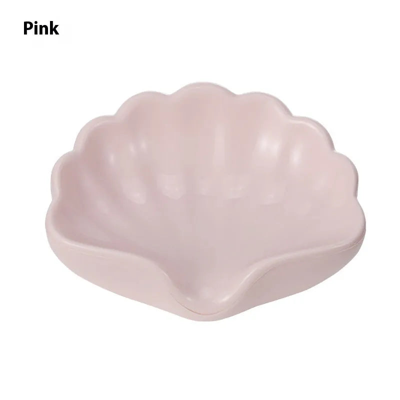 White and pink shell-shaped plastic soap dish on a bathroom countertop