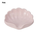 White and pink shell-shaped plastic soap dish on a bathroom countertop