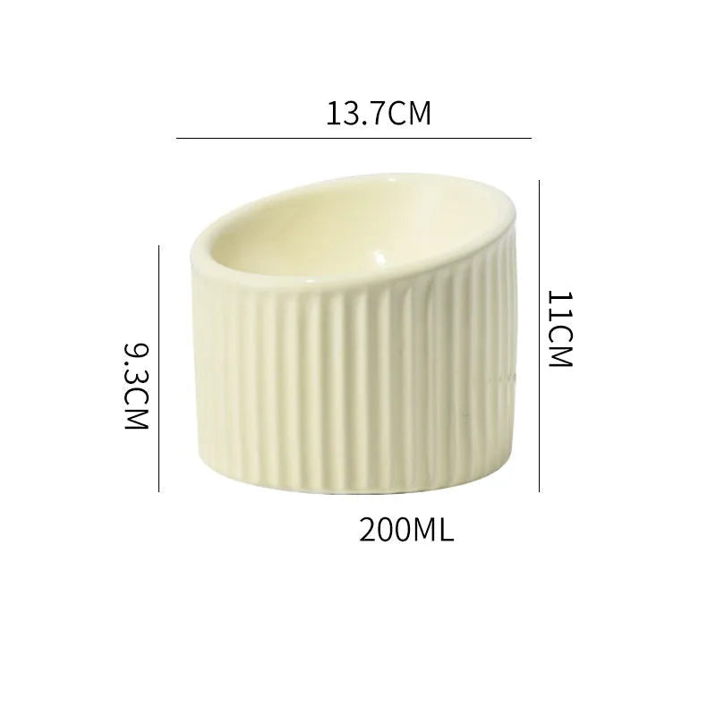 Dark green ceramic elevated cat bowl with round, whisker-friendly shape on a tilted base.