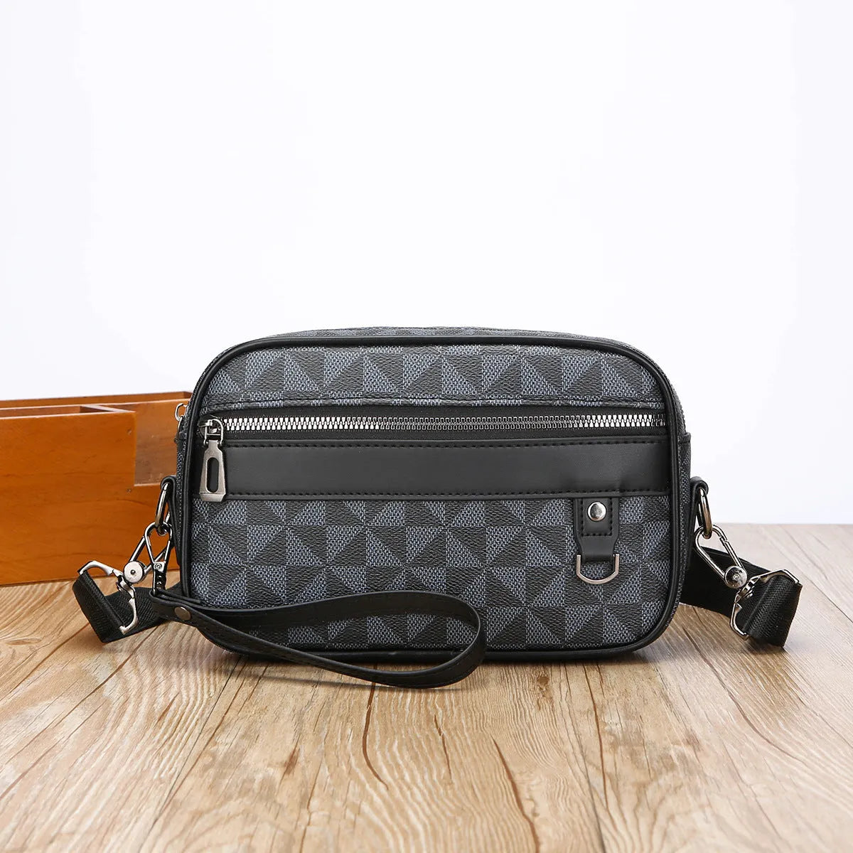 Men's black geometric pattern messenger bag showing shoulder strap and handheld carrying options