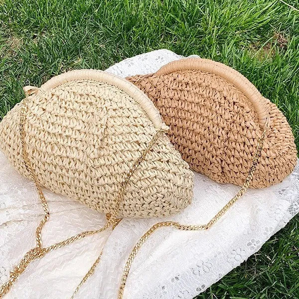Women's khaki straw shoulder bag with chain detail and shell shape on a neutral background