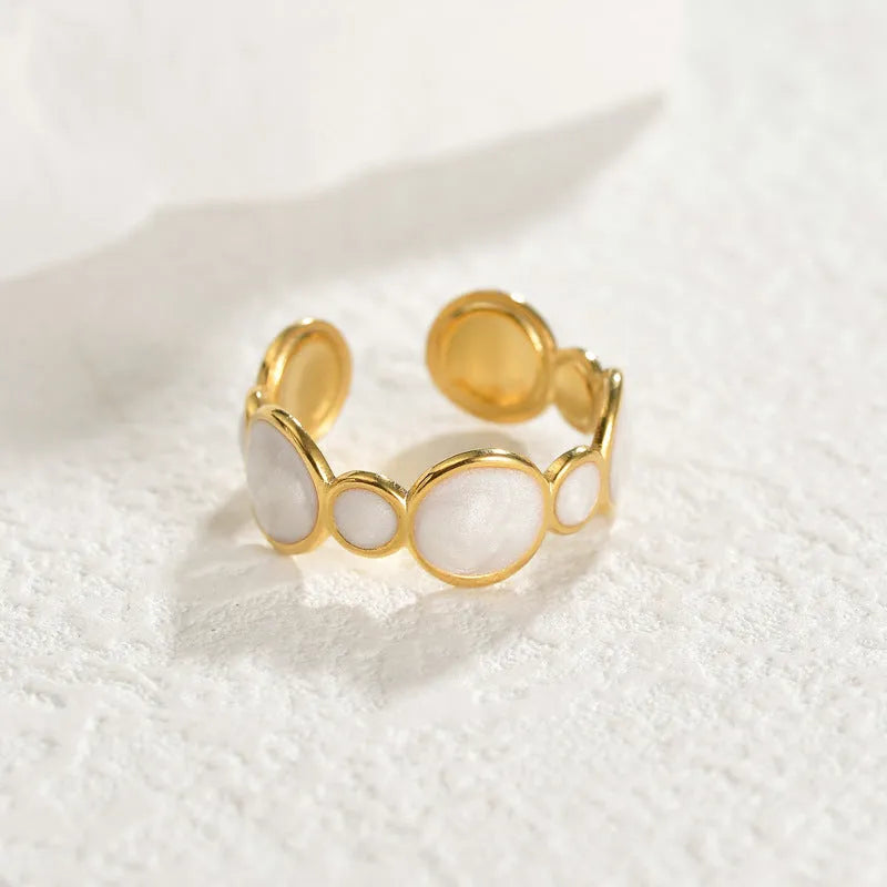 Adjustable geometric stainless steel ring for women on a plain background.