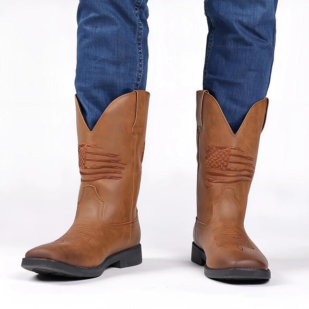 Men's brown retro cowboy boot with square toe and horseshoe heel on a wooden floor.