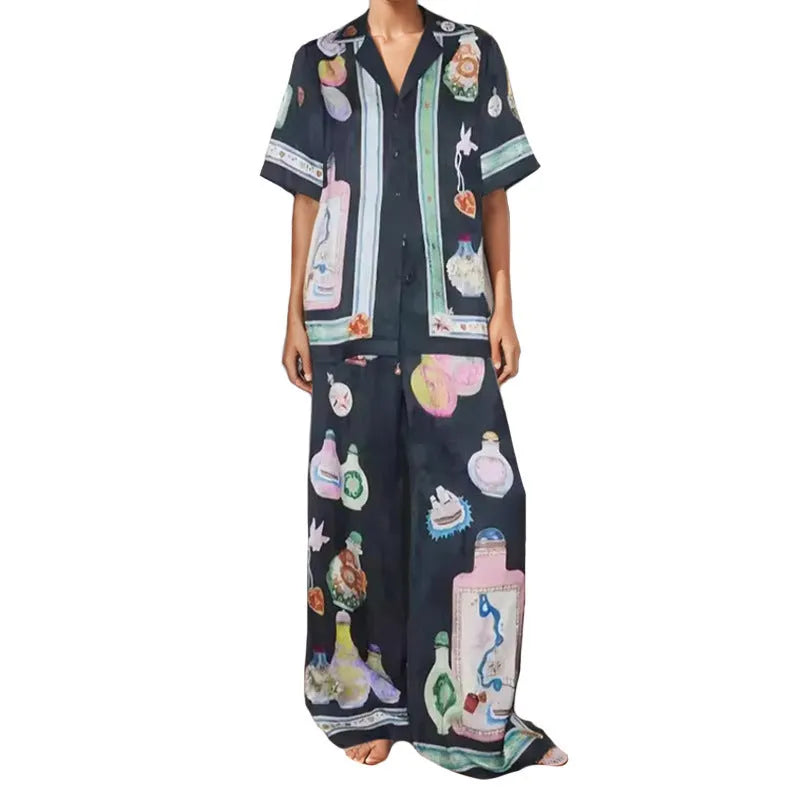 Black women's cardigan and pants set with cartoon animation pattern, shown laid flat.