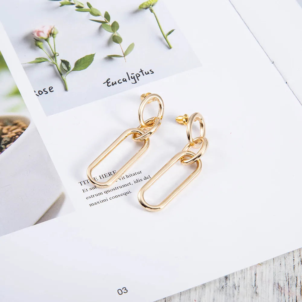Geometric sterling silver coloured alloy hoop earrings for women with a ring and line design.