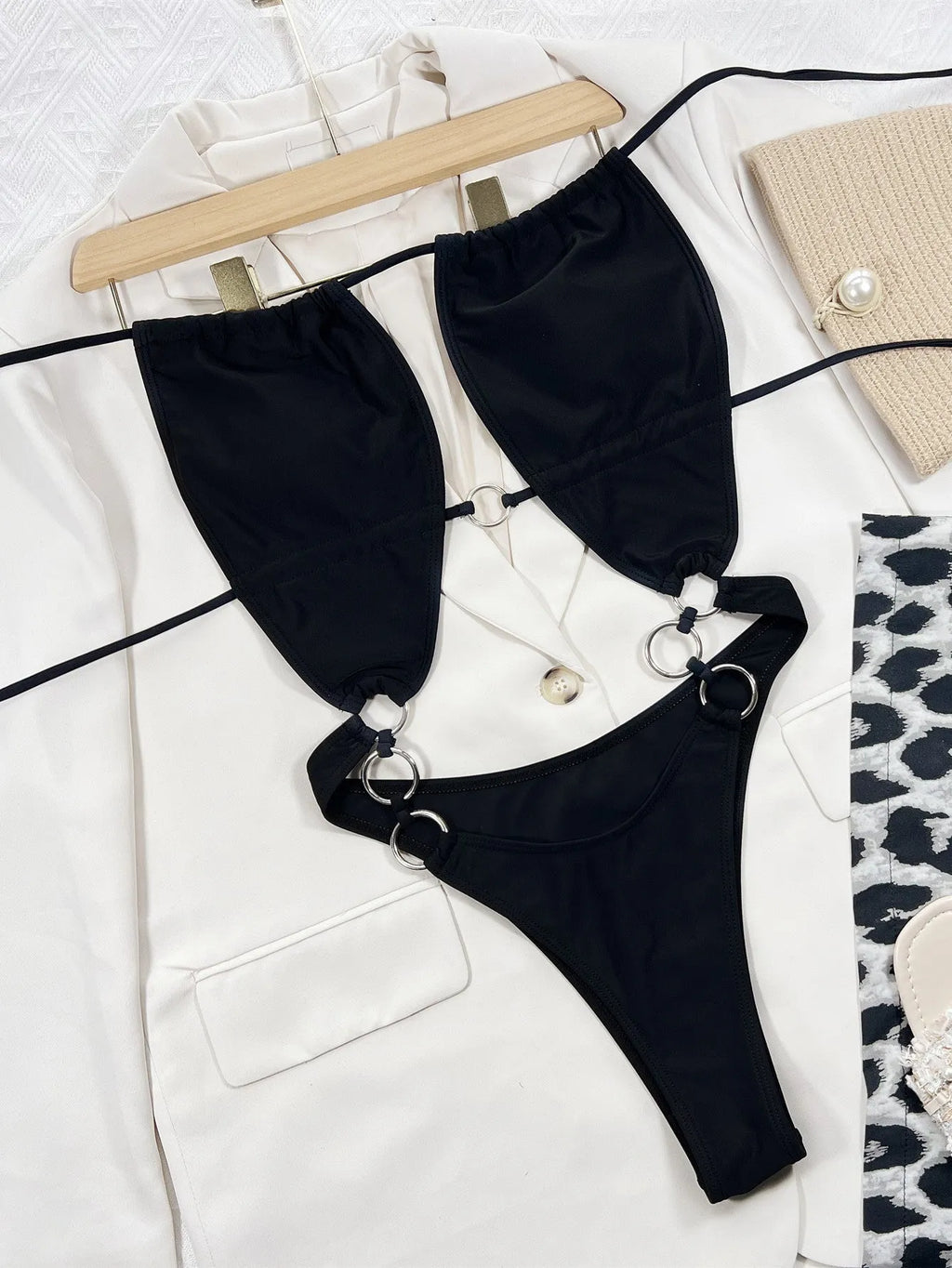 Black sleeveless one-piece swimsuit for women on a hanger.