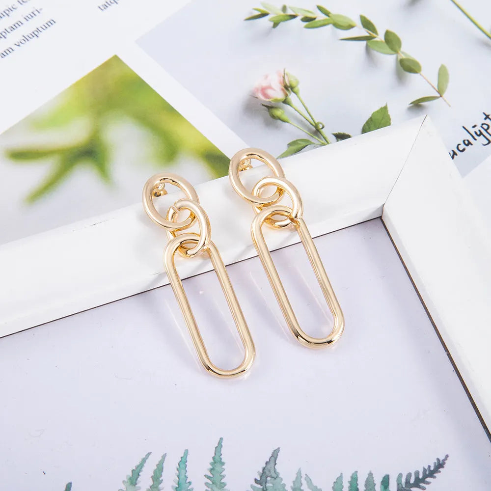 Geometric sterling silver coloured alloy hoop earrings for women with a ring and line design.