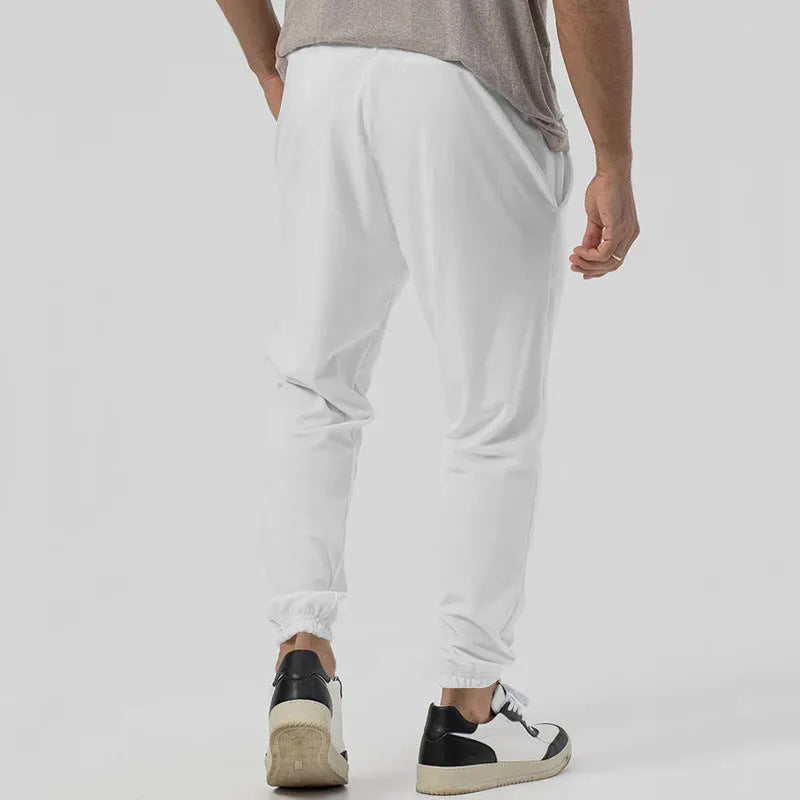 Men's grey casual track sweatpants with straight-leg design and mid waist, made from polyester blend elastic fabric