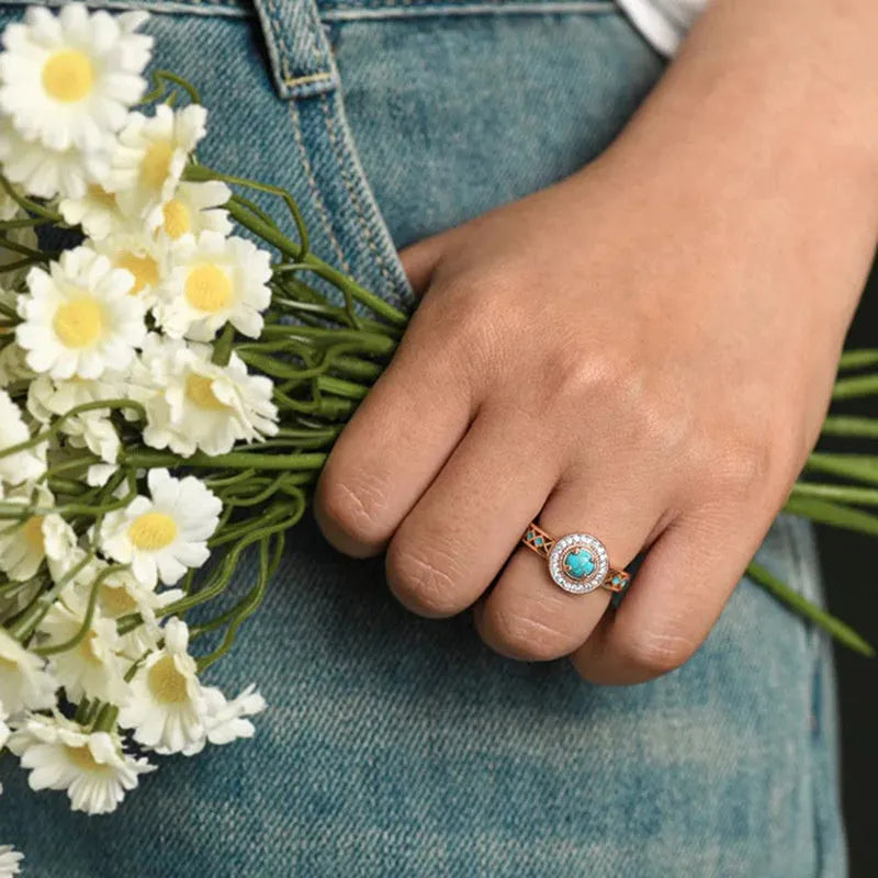 Women's turquoise geometric square ring with inlaid zircon stones on a rose gold band.