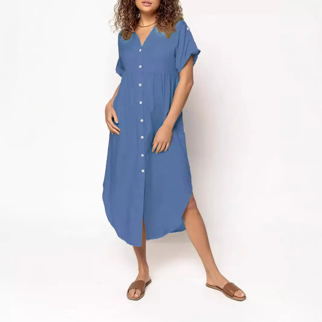 A woman wearing a loose-fitting, mid-length apricot-coloured casual dress with a button-down front.