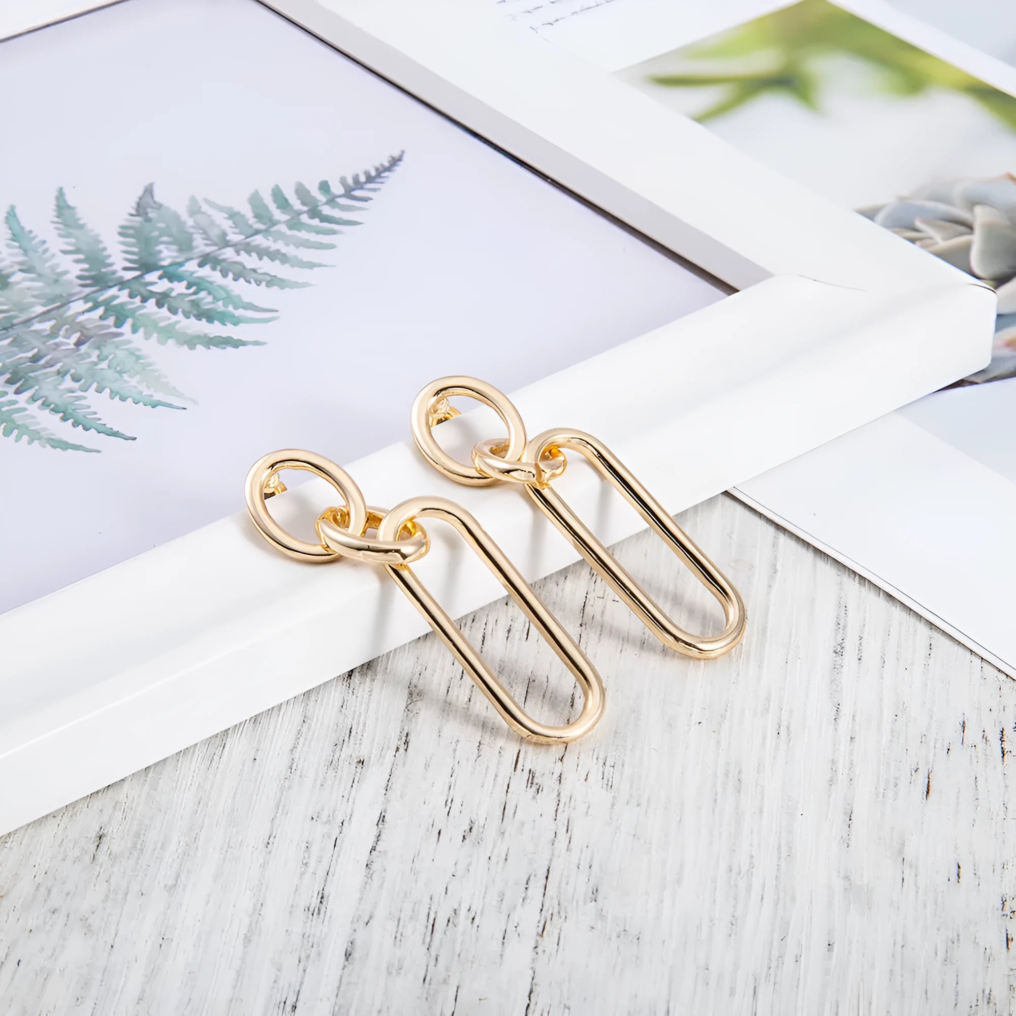 Geometric sterling silver coloured alloy hoop earrings for women with a ring and line design.