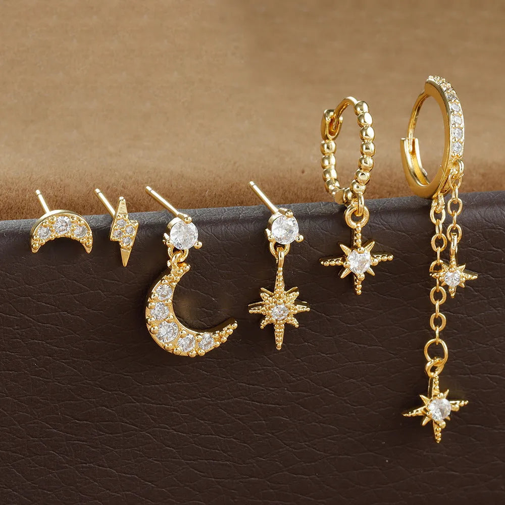 Six pairs of gold chain tassel earrings with zircon stones arranged in display