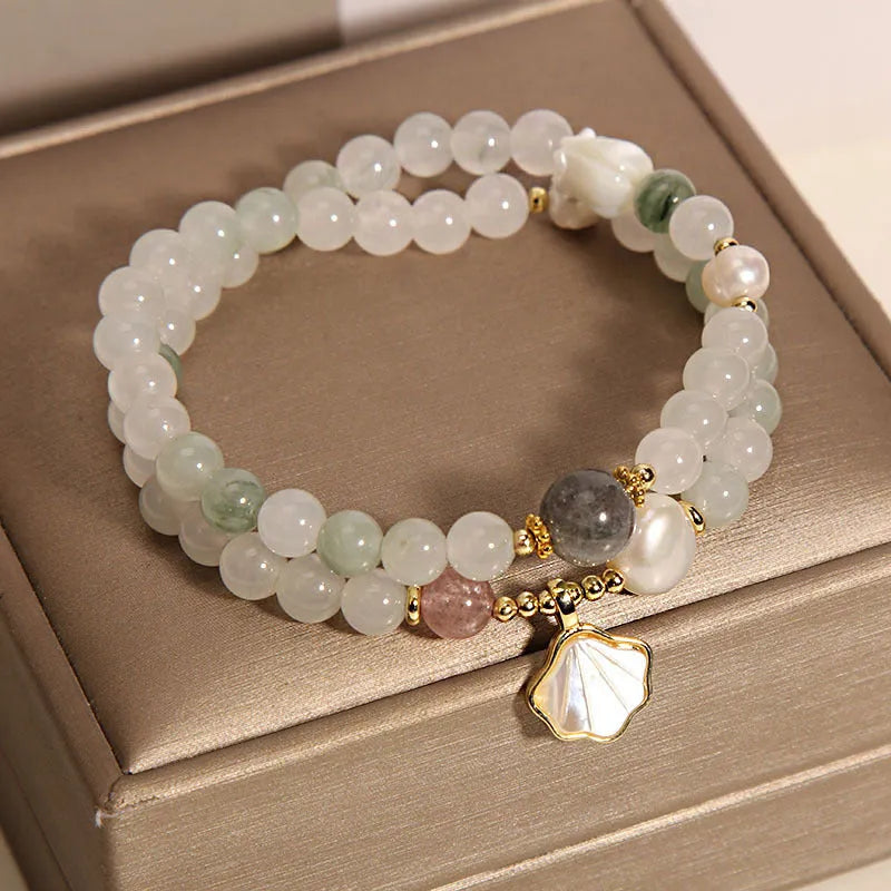 Women's emerald green crystal bracelet with gold ginkgo leaf pendant and rhinestone accents