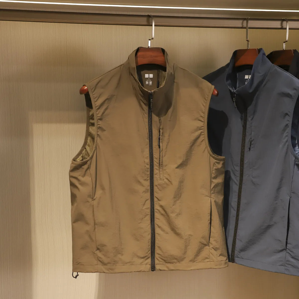 Men's straight-cut nylon vest cardigan in army green with side seam pockets, shown open as a lightweight layer.