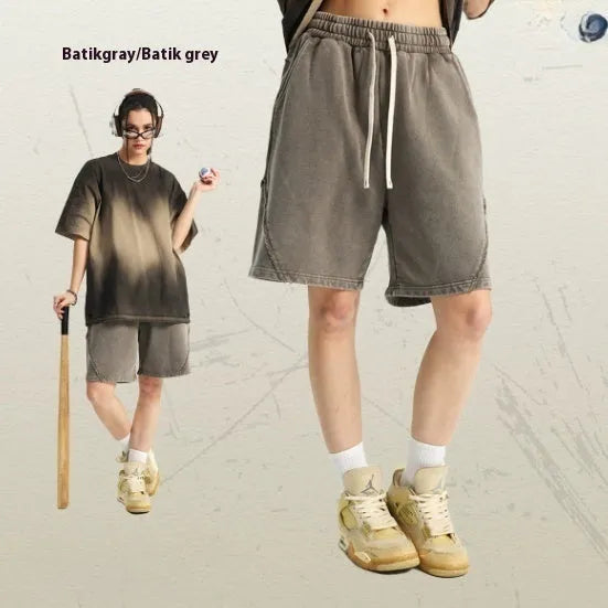 Man wearing loose-fit batik washed cotton terry shorts in a retro style with patch craft details.