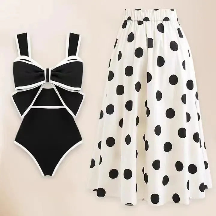 Women's black one-piece swimsuit with a white bow and round skirt on a mannequin.