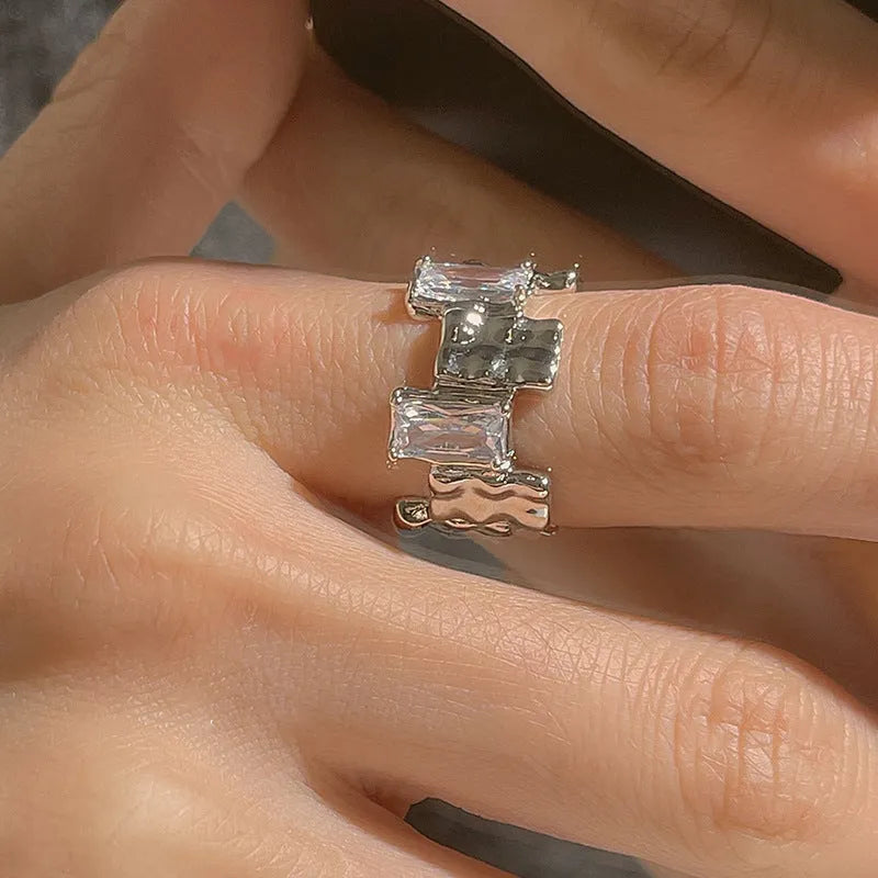 Open geometric zircon ring with three-dimensional decoration in silver colour