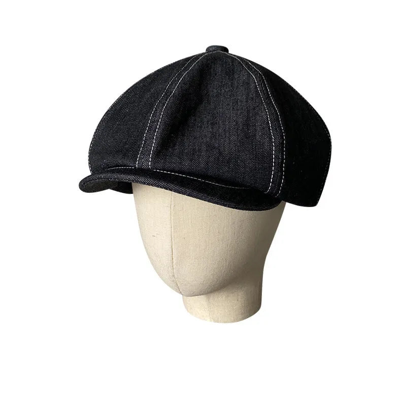 Black cotton retro-style beret for men and women on a plain background.