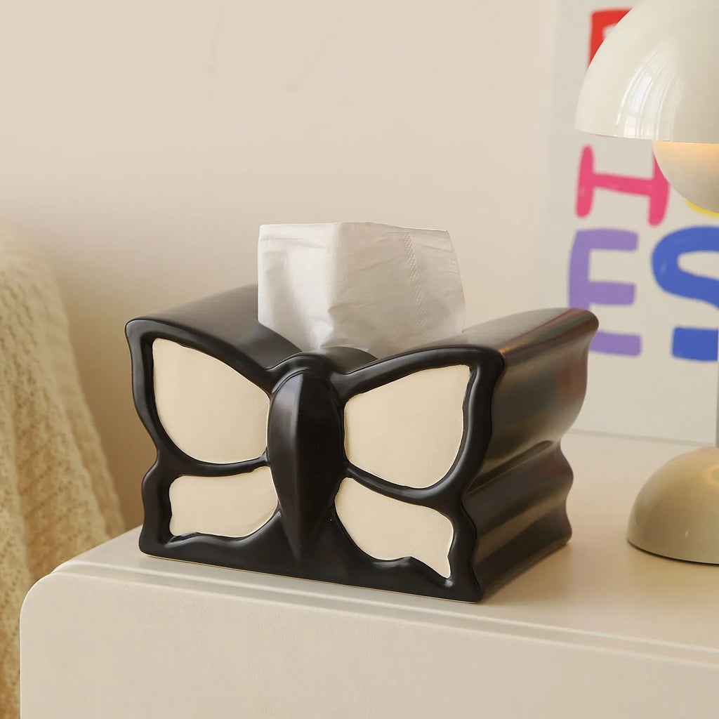 Ceramic butterfly vase and matching tissue box set on a living room table.