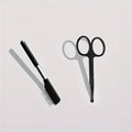 Black handheld pet grooming brush with a soft silicone head for eye tear stain removal.