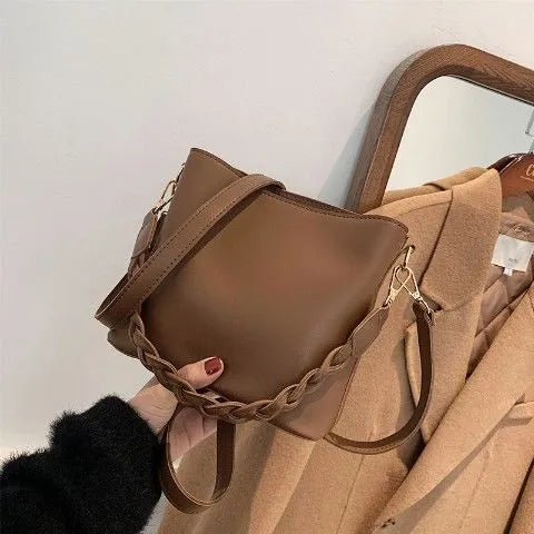 Woven texture PU leather crossbody bucket bag in neutral colour showing one-shoulder underarm carrying design