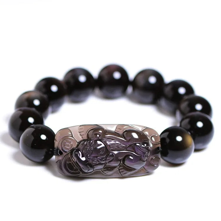 Polished natural crystal Pi Xiu bracelet with geometric ethnic design on a wrist.