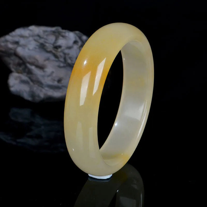 Natural light jade bracelet with a polished finish on a wrist, showing its Chinese style.