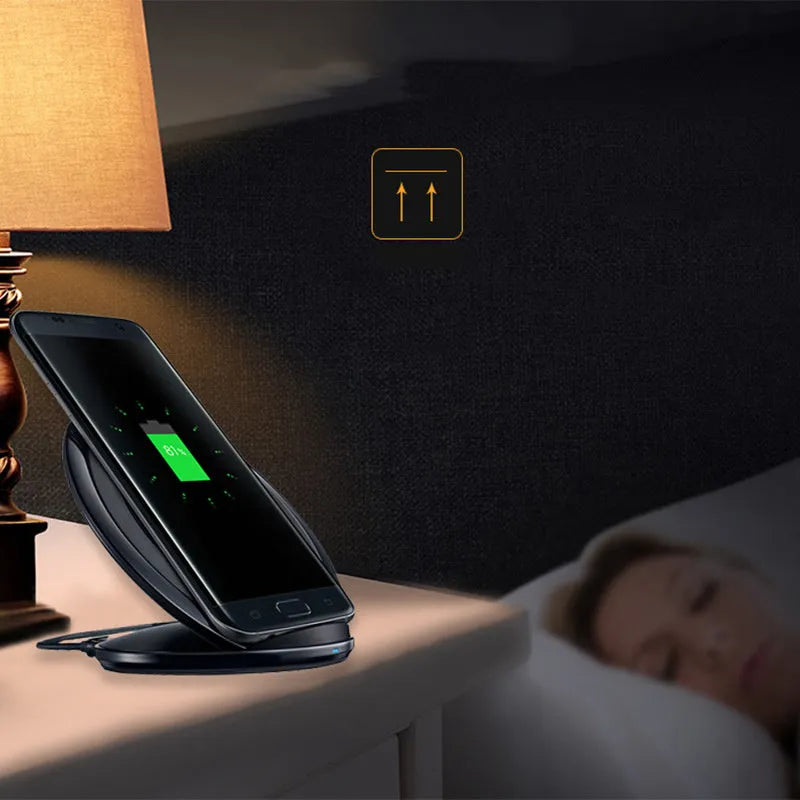 A black or white wireless charging pad for a Samsung Galaxy Note Edge mobile phone on a desk.