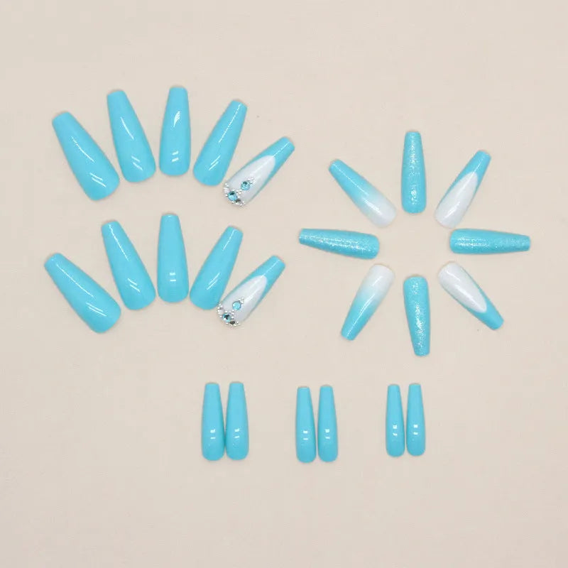Long ballet false nails with blue diamond glitter on solid colour background with nail glue bottle
