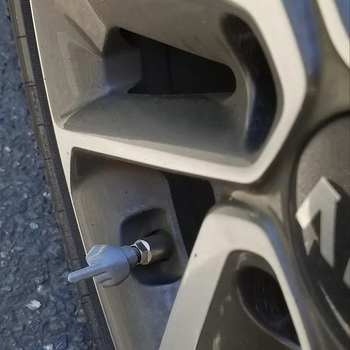 Four latex car tyre valve dust caps showing black and skin colour pieces for valve stem protection