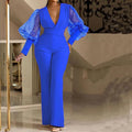 Red women's jumpsuit with mesh stitching on the bodice, long sleeves, and wide-leg trousers.